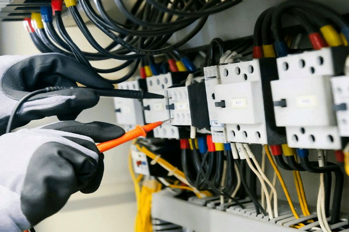 Técnico verificando contatores e relés em painel de comando